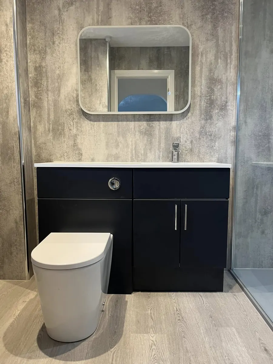 Navy combination vanity and WC unit with white basin, LED mirror and textured wall panelling