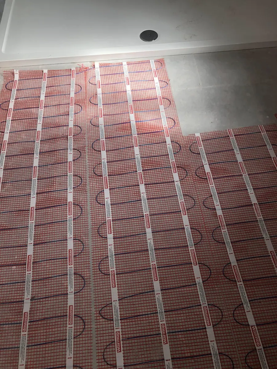Warmup electric underfloor heating mats laid across a bathroom floor around the shower tray before tiling
